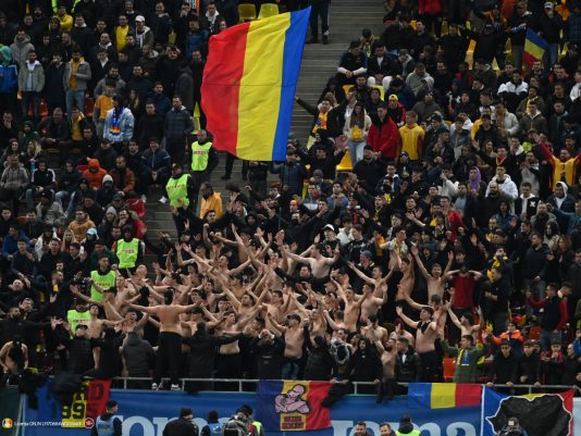 Suporterii romani isi incurajeaza favoritii la meciul de fotbal dintre Romania si Belarus, din cadrul preliminariilor Ca